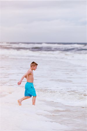 preteen boys playing - Boy running into sea, Dauphin Island, Alabama, USA Stock Photo - Premium Royalty-Free, Code: 649-09124038