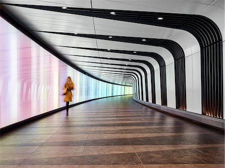 Rear view of woman walking through tunnel walkway, London City Airport, London, UK Stock Photo - Premium Royalty-Free, Code: 649-09123614