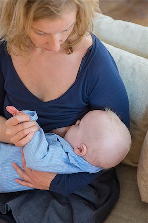 Woman breast feeding baby son on sofa Stock Photo - Premium Royalty-Free, Code: 649-09123620