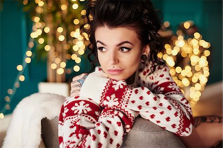 pierced ears - Young woman sitting at home, wearing christmas jumper, thoughtful expression Stock Photo - Premium Royalty-Free, Code: 649-09123653