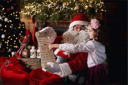 simsearch:640-03260410,k - Young girl visiting Santa, pointing to list Stock Photo - Premium Royalty-Free, Code: 649-09123662