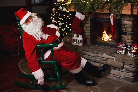 Santa Claus, sleeping in chair beside fireplace Stock Photo - Premium Royalty-Free, Code: 649-09123681
