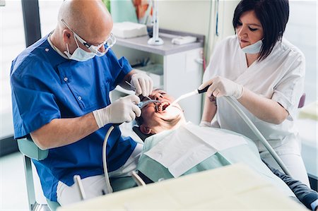 simsearch:649-07709952,k - Dentist and dental nurse carrying out procedure on male patient Stock Photo - Premium Royalty-Free, Code: 649-09138878