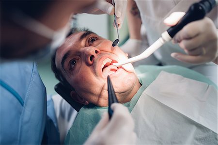 simsearch:649-07280884,k - Dentist looking into male patient's mouth, elevated view Foto de stock - Sin royalties Premium, Código: 649-09138872