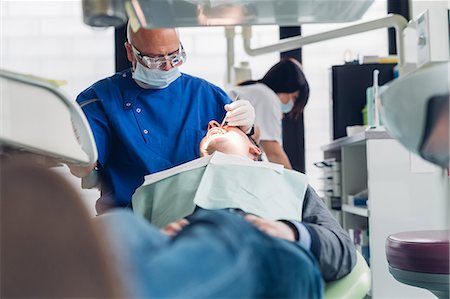 simsearch:649-07709952,k - Dentist carrying out dental procedure on male patient Stock Photo - Premium Royalty-Free, Code: 649-09138880