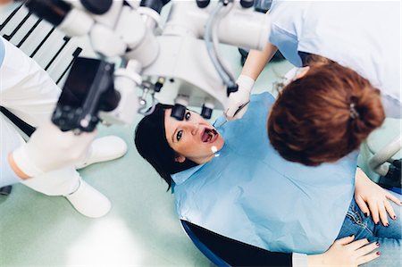 dentist - Dentist carrying out procedure on female patient, elevated view Stock Photo - Premium Royalty-Free, Code: 649-09138906