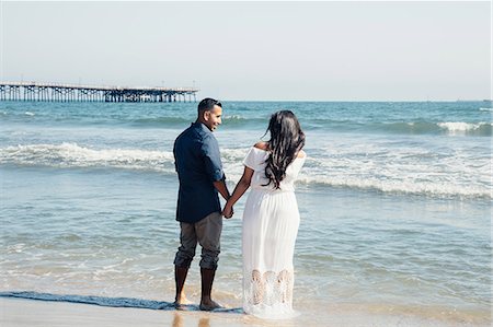 simsearch:649-08239088,k - Couple standing on beach, holding hands, rear view, Seal Beach, California, USA Stock Photo - Premium Royalty-Free, Code: 649-09139186
