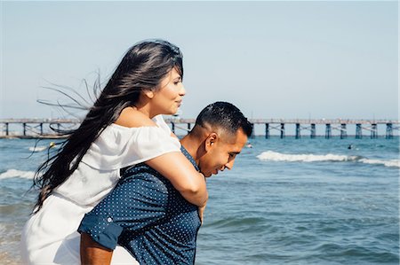 simsearch:649-08239088,k - Man giving woman piggyback along beach, Seal Beach, California, USA Stock Photo - Premium Royalty-Free, Code: 649-09139187