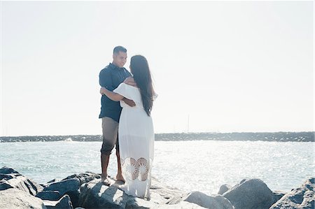 simsearch:649-08239088,k - Couple standing on coastal rock, face to face, Seal Beach, California, USA Stock Photo - Premium Royalty-Free, Code: 649-09139189