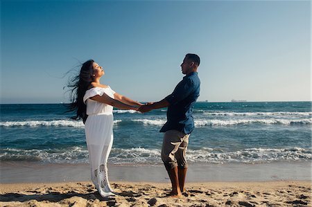 simsearch:649-08239088,k - Couple standing on beach, holding hands, face to face, Seal Beach, California, USA Stock Photo - Premium Royalty-Free, Code: 649-09139195