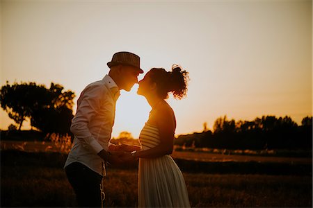 Heterosexual couple in field at sunset, holding hands, face to face Photographie de stock - Premium Libres de Droits, Code: 649-09139210