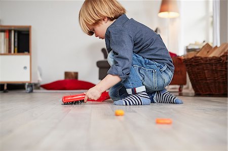 Young boy playing with toy dustpan and brush Stock Photo - Premium Royalty-Free, Code: 649-09139272