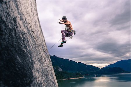 Man with climbing rope jumping off rock face on Malamute, Squamish, Canada Stock Photo - Premium Royalty-Free, Code: 649-09155669