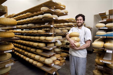 simsearch:649-06164558,k - Portrait of cheese maker carrying hard cheeses for inspection, in ageing room where hard cheeses are stored Photographie de stock - Premium Libres de Droits, Code: 649-09156369