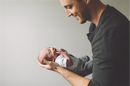 simsearch:859-06808650,k - Father holding newborn baby boy smiling Stock Photo - Premium Royalty-Free, Code: 649-09166573