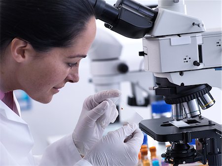 simsearch:649-07279799,k - Scientist viewing human sample on glass slide under microscope Stock Photo - Premium Royalty-Free, Code: 649-09166687
