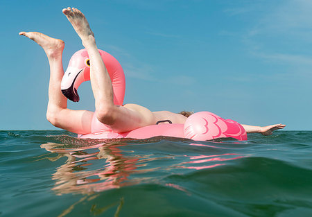 Nude man playing on inflatable flamingo at sea Fotografie stock - Premium Royalty-Free, Codice: 649-09177186