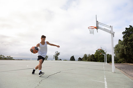 Male teenage basketball player running with ball on basketball court Stock Photo - Premium Royalty-Free, Code: 649-09182164