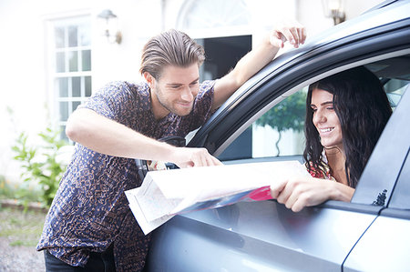 front seat - Couple in parked car outside front door looking at folding map Stock Photo - Premium Royalty-Free, Code: 649-09182414