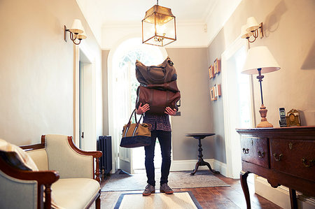 funny vacation - Young man carrying stack of luggage in hotel lobby Stock Photo - Premium Royalty-Free, Code: 649-09182439