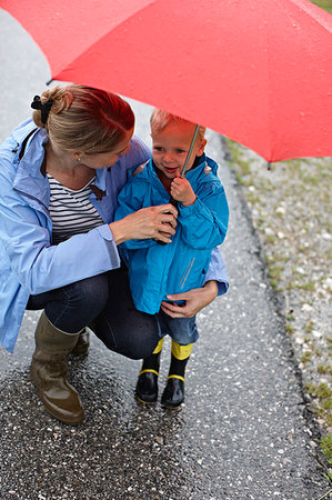 simsearch:6113-06899525,k - Mother and son with umbrella on road Stock Photo - Premium Royalty-Free, Code: 649-09205800