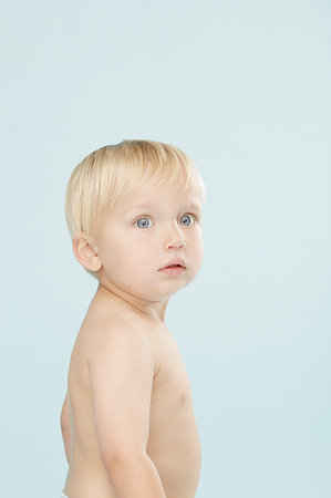 simsearch:632-03027302,k - Surprised baby looking over his shoulder Stock Photo - Premium Royalty-Free, Code: 649-09206251