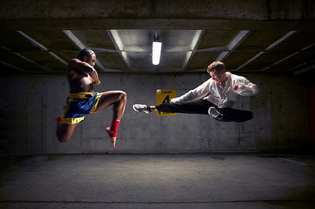 simsearch:6122-08212737,k - Boxer and kick boxer mid air in parking lot Stock Photo - Premium Royalty-Free, Code: 649-09206739