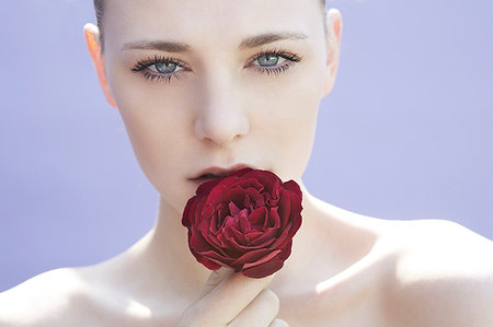 simsearch:649-07436630,k - Studio head shot of young woman holding rose to her lip Stock Photo - Premium Royalty-Free, Code: 649-09207461