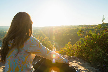 simsearch:649-07279678,k - Mid adult woman sitting on elevated rock watching sunrise Stock Photo - Premium Royalty-Free, Code: 649-09207560