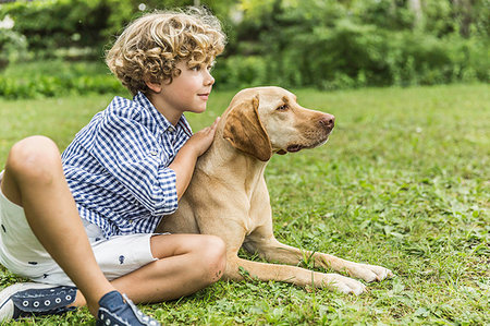 simsearch:6122-07698204,k - Portrait of boy sitting petting dog in garden Stock Photo - Premium Royalty-Free, Code: 649-09208294