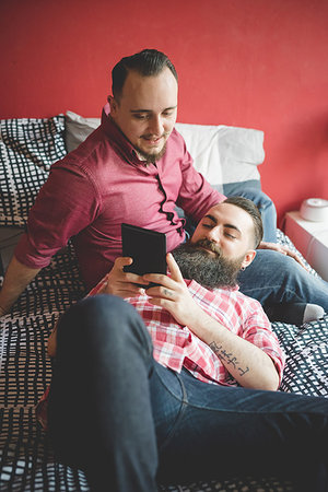 Gay couple using smartphone in bedroom Stock Photo - Premium Royalty-Free, Code: 649-09208855