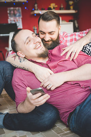 Gay couple using smartphone in bedroom Stock Photo - Premium Royalty-Free, Code: 649-09208863