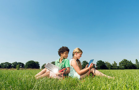 simsearch:649-07804673,k - Girl and boy sitting back to back in field using digital tablets Photographie de stock - Premium Libres de Droits, Code: 649-09208907