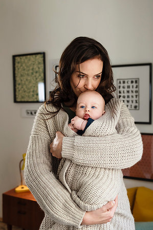 simsearch:6113-06720631,k - Woman kissing baby son, wrapping him in her cardigan Photographie de stock - Premium Libres de Droits, Code: 649-09209012
