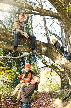 simsearch:649-07280282,k - Mother lifting up daughter to father sitting on branch in tree smiling Stock Photo - Premium Royalty-Free, Code: 649-09209297