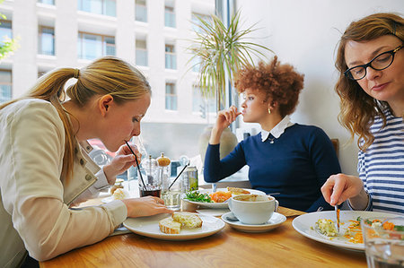 Three women eating salad lunch in cafe Stock Photo - Premium Royalty-Free, Code: 649-09209476
