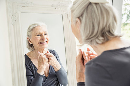 photos of 70 year old women faces - Grey haired senior woman looking at hands and face in mirror Stock Photo - Premium Royalty-Free, Code: 649-09209608