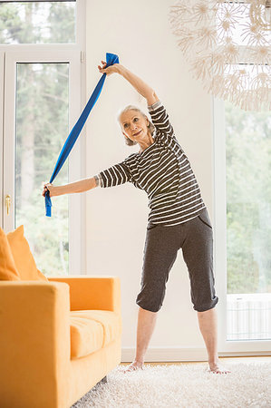 simsearch:693-05552857,k - Senior woman exercising in living room using resistance band Stock Photo - Premium Royalty-Free, Code: 649-09209622