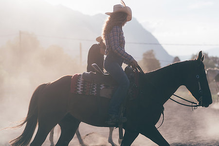 Cowgirl horse riding in dusty equestrian arena, sideview Primaluna, Trentino-Alto Adige, Italy Stock Photo - Premium Royalty-Free, Code: 649-09212971