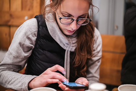 simsearch:649-06845199,k - Young woman using smartphone in cafe Stock Photo - Premium Royalty-Free, Code: 649-09213179