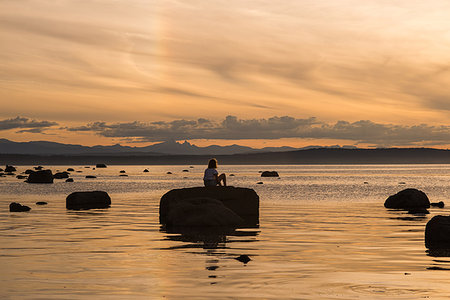 simsearch:614-07487145,k - Young woman sitting on rock at sunset, Quadra Island, Campbell River, Canada Photographie de stock - Premium Libres de Droits, Code: 649-09213588