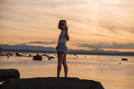 simsearch:614-07487145,k - Young woman standing on rock at sunset, portrait, Quadra Island, Campbell River, Canada Photographie de stock - Premium Libres de Droits, Code: 649-09213589