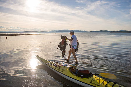 Mature female kayaker carrying life jackets from kayak, Quadra Island, Campbell River, Canada Stock Photo - Premium Royalty-Free, Code: 649-09213580