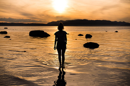 simsearch:649-08924209,k - Young woman looking out at sunset, silhouetted rear view, Quadra Island, Campbell River, Canada Stock Photo - Premium Royalty-Free, Code: 649-09213590