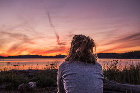 simsearch:649-08924209,k - Young woman looking out at sunset, rear view, Quadra Island, Campbell River, Canada Stock Photo - Premium Royalty-Free, Code: 649-09213591