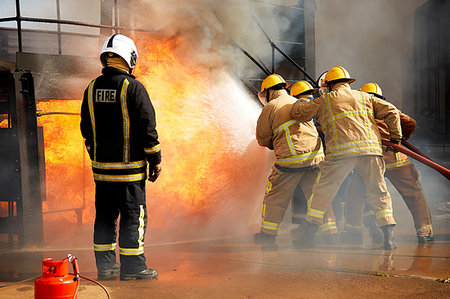simsearch:649-07239830,k - Firemen training, firemen spraying water at fire at training facility, rear view Stock Photo - Premium Royalty-Free, Code: 649-09230178