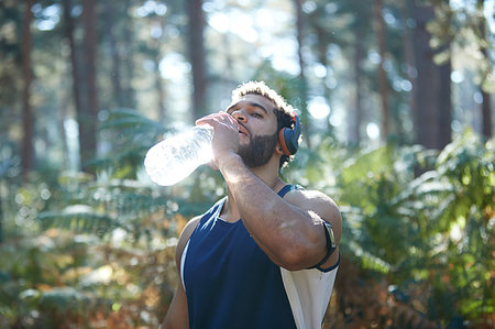 simsearch:693-07672615,k - Male runner drinking bottled water in sunlit forest Stock Photo - Premium Royalty-Free, Code: 649-09230222