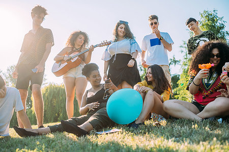 simsearch:649-07239413,k - Group of friends relaxing, playing guitar at picnic in park Stock Photo - Premium Royalty-Free, Code: 649-09257729