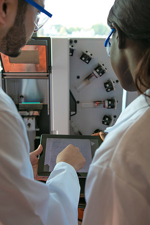 simsearch:649-07585094,k - Young female and male scientists looking at digital tablet in laboratory, over shoulder view Stock Photo - Premium Royalty-Free, Code: 649-09258378