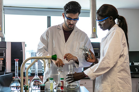 simsearch:649-08085222,k - Young male and female scientists preparing experiment with sample bottles in laboratory Stock Photo - Premium Royalty-Free, Code: 649-09258390